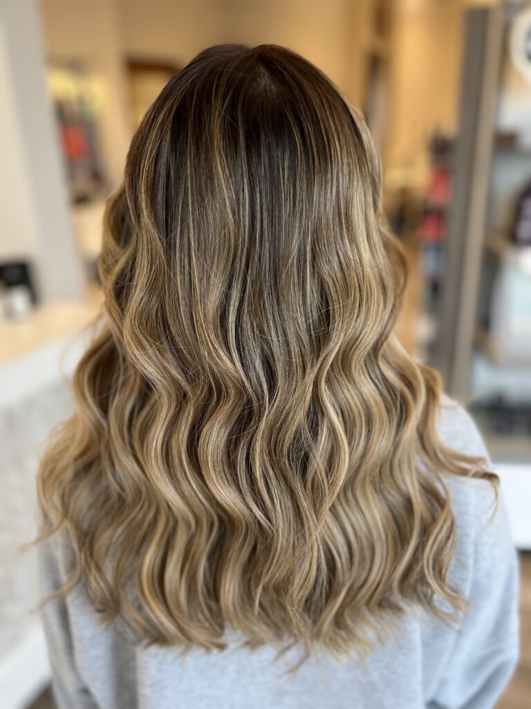 Long waves with blonde highlights at Taylor Stevens Salon